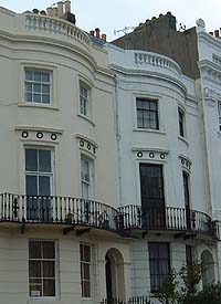 Shows a photograph of two typical Regency houses with laurel wreath designs above the first floor windows.